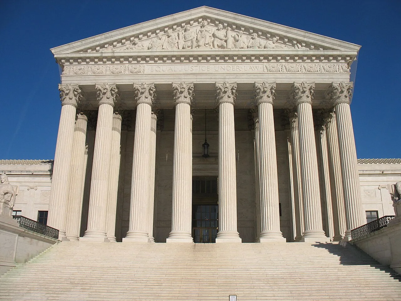 The front of the United States Supreme Court building: a broad flight of marble steps rising to a row of columns beneath a carved pediment.